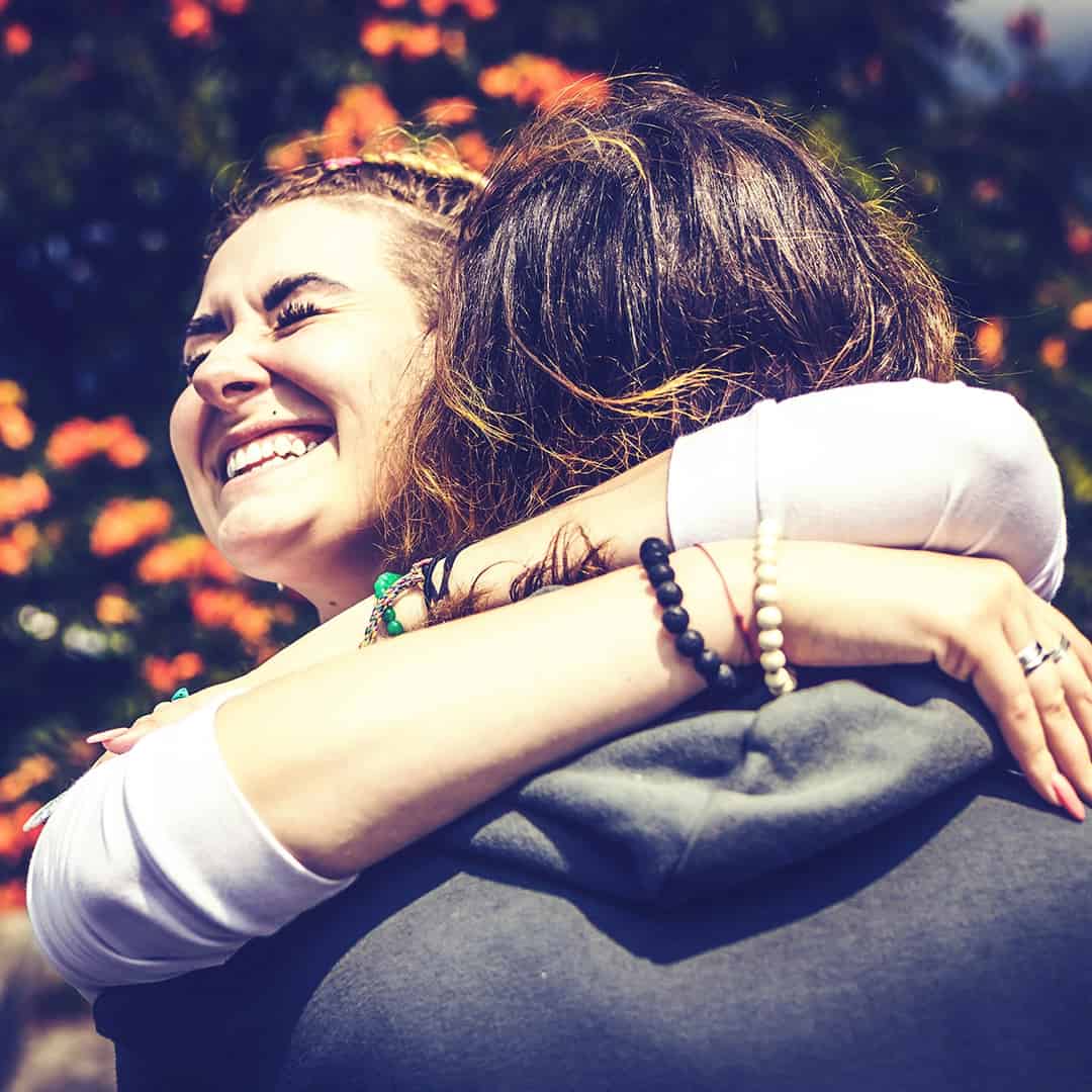 Two friends sharing a heartfelt embrace outdoors